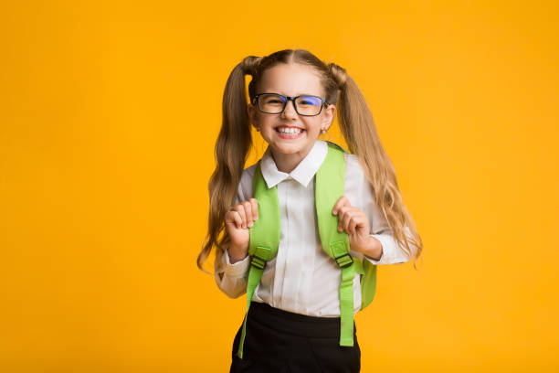 istock Happy Schoolgirl Smiling Posing At Camera, Yellow Background, Studio Shot 1173558002