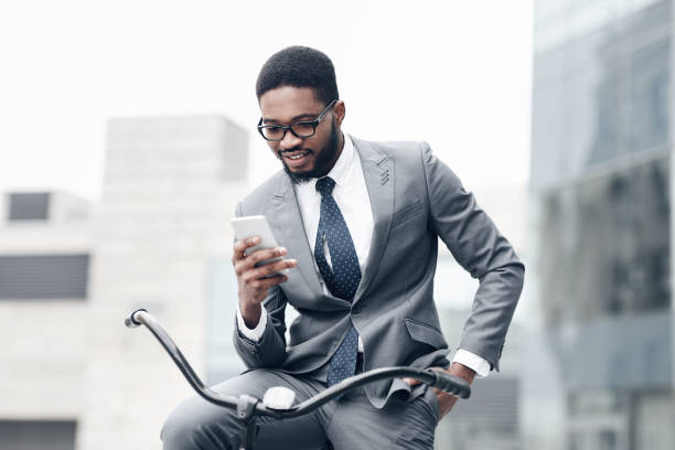istock Handsome businessman using smartphone, riding on bicycle 1173558288