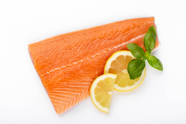 istock Fresh raw salmon fillets with herbs and lemon isolated on white background. 1173559415