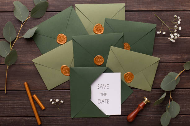 Composition of wedding envelopes with invitations on wood