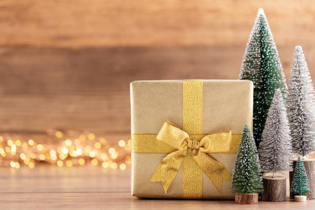 istock Christmas gift boxes with ribbons and tree on bokeh background. 1173560882