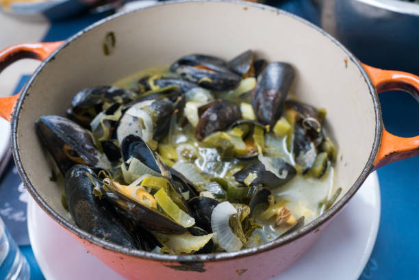 close up view of traditional mussel and french fries dish called "Moules et Frites" Horizontal view of traditional mussel and french fries dish called "Moules et Frites" moules frites stock pictures, royalty-free photos & images