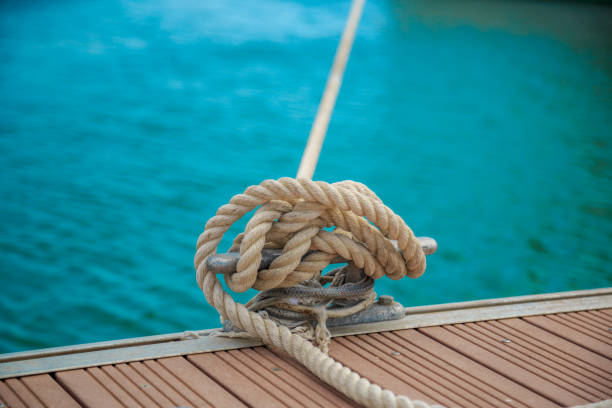 швартовка яхты веревка с завязанным концом связали вокруг cleat на деревянном пирсе - moored nautical vessel tied knot sailboat стоковые фото и изображения