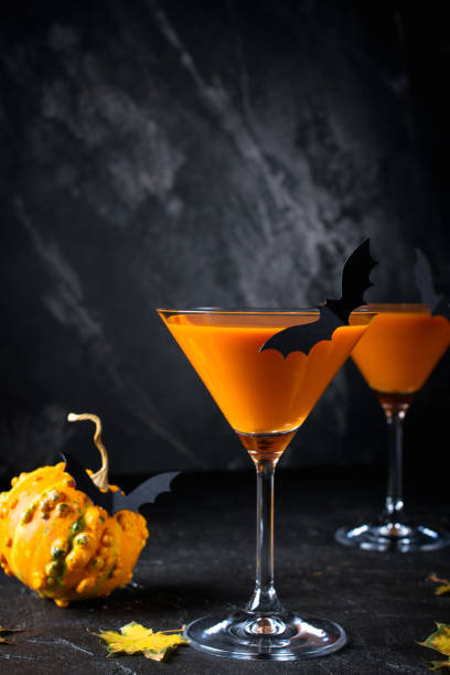 istock Halloween orange drink with  bats on dark background, spooky 1173561283