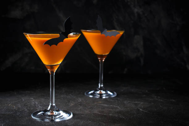 istock Orange pumpkin  martini Halloween drink for party over black background with copy space 1173561293
