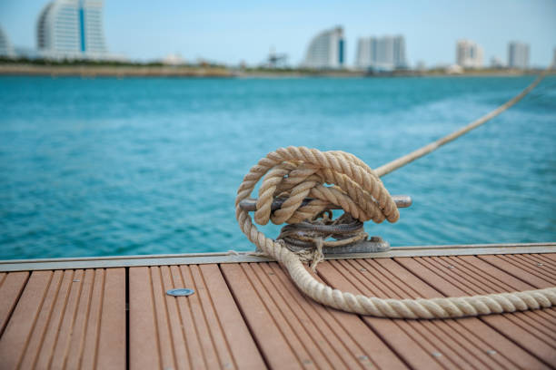 швартовная яхтенная веревка с завязанным концом, завязанная вокруг щетины на деревянном пирсе - moored nautical vessel tied knot sailboat стоковые фото и изображения