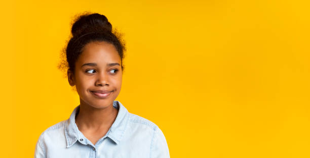 istock Pensive girl looking aside at empty space on yellow background 1173563677