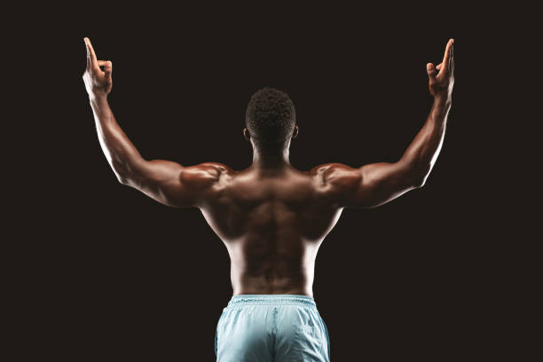 istock Back view of african bodybuilder raising his hands up 1173563852