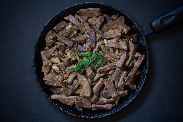 istock Cooked liver on frying pan on the black background 1173564098