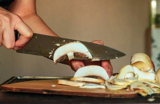 istock woman's hand cutting mushrooms in kitchen 1173564787