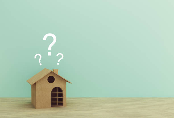 istock Paper house model with question marks on wood table with blue background. copy space for your text. 1173564902