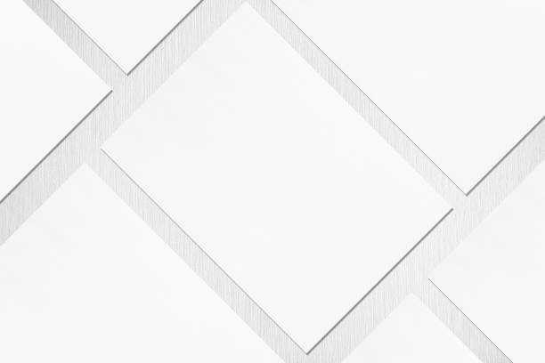 薄い灰色のテクスチャの背景に斜めに横たわっている空の白い長方形のポスターやカードモックアップのクローズアップ - diagonally ストックフォトと画像