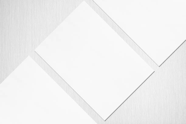 istock Close up of three empty white rectangle poster or card mockups lying diagonally 1173565122