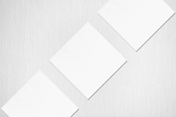 istock Three empty white square business card mockups with soft shadows lying diagonally 1173565157