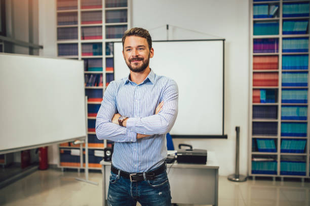 Smiling male coach giving presentation for audience in lecture hall