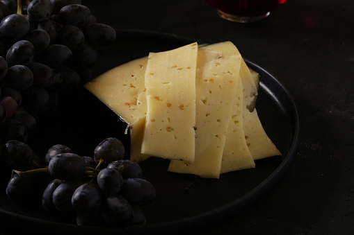 cheese and black grapes on a plate