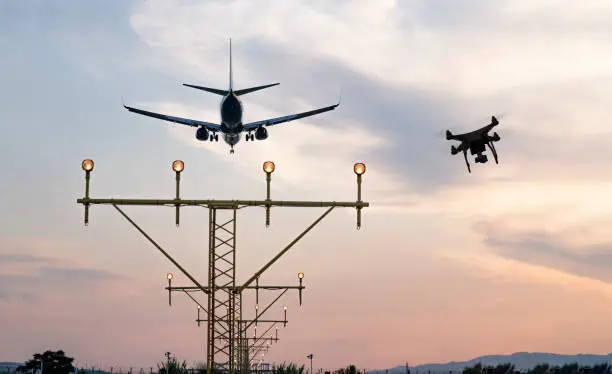 Photo of Drone flying at the airport near an aircraft leading to a possible crash or accident. Illegal UAV flight inside the airport conceptual montage
