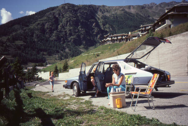 giovane famiglia con un saab 900 azzurro che si gode un picnic nelle alpi svizzere. - saab casa automobilistica foto e immagini stock
