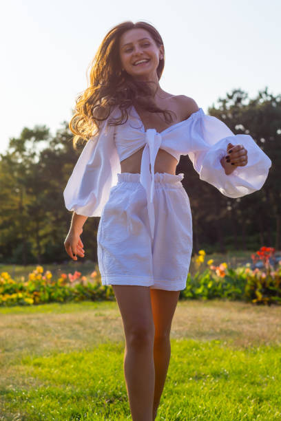 young beautiful woman with bare shoulders in white clothes in the garden - stripped shirt imagens e fotografias de stock