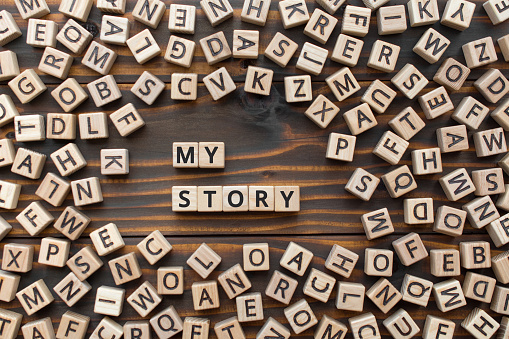 My story - phrase from wooden blocks with letters, Personal History Achievement Biography My story concept, random letters around, white  background