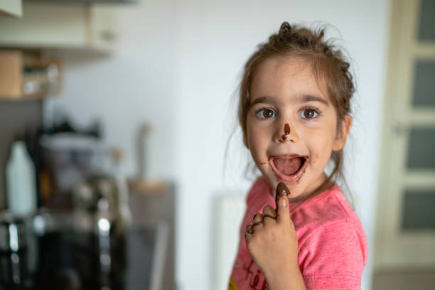 dziewczyna jedząca czekoladę z palcem - finger licking zdjęcia i obrazy z banku zdjęć
