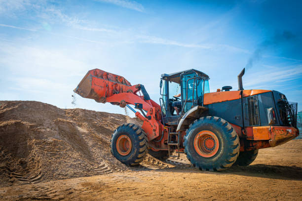 istock Yellow excavator on a construction site against blue sky. wheel loader at sandpit during earthmoving works 1173574308