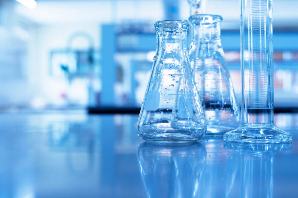 istock glass flask and cylinder with water drop in blue chemistry science laboratory 1173574404