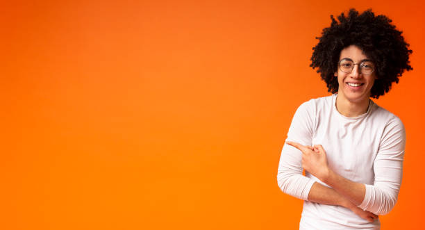 istock Awesome black guy in glasses pointing away at copy space 1173574474