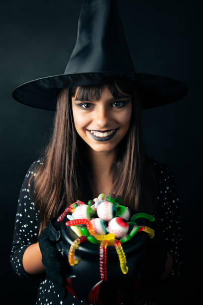 istock Happy young witch holding Halloween candies 1173581055
