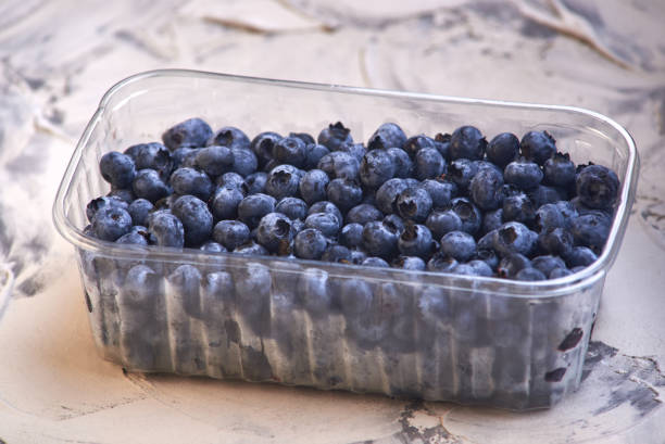 istock fresh and tasty Blueberries in a plastic can on old rustic wooden table 1173581127