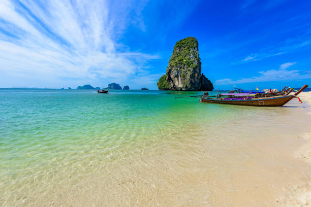 ao phra nang beach - тайская традиционная деревянная длиннохвостая лодка на полу�острове райлай перед известняковыми карстовыми скалами, недалеко � - phuket province beach blue cliff стоковые фото и изображения