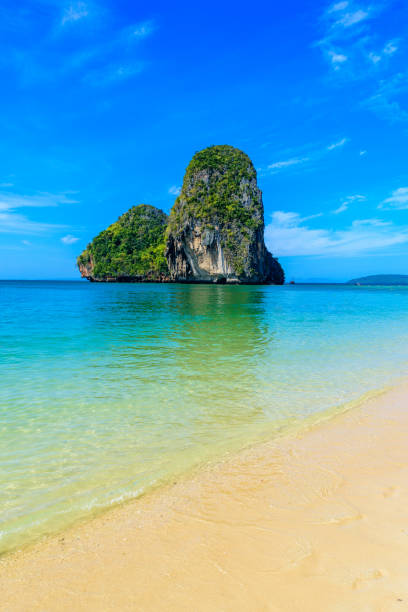 ao phra nang beach - thai traditional wooden longtail boat on railay peninsula in front of limestone karst rocks, close to ao nang, krabi province, andaman sea, thailand - phuket province beach blue cliff imagens e fotografias de stock