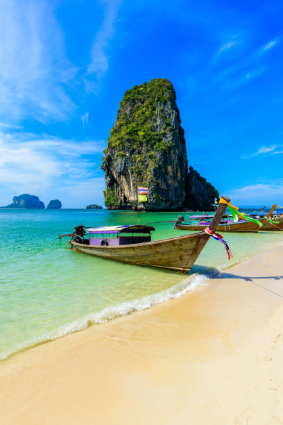 ao phra nang beach - тайская традиционная деревянная длиннохвостая лодка на полуострове райлай перед из�вестняковыми карстовыми скалами, недалеко � - phuket province beach blue cliff стоковые фото и изображения