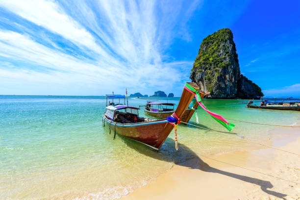 ao phra nang beach - тайская традиционная деревянная длиннохвостая лодка на полуострове райлай перед известняковыми карстовыми скалами, недалеко � - phuket province beach blue cliff стоковые фото и изображения