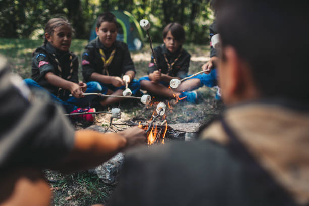 istock Group Of Scouts Roast Marshmallow Candies On Campfire In Forest 1173583118