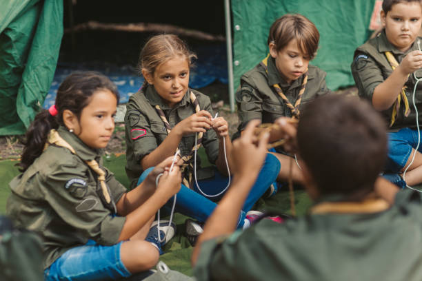 15 years old boy scout teaching boys and girls how to tie the knots.