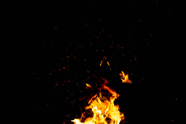 istock Burning red hot sparks fly from large fire in the night sky. Beautiful abstract background on the theme of fire, light and life. 1173584025
