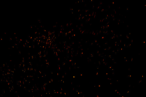 Las chispas rojas ardientes vuelan desde un gran incendio en el cielo nocturno. Hermoso fondo abstracto sobre el tema del fuego, la luz y la vida. photo