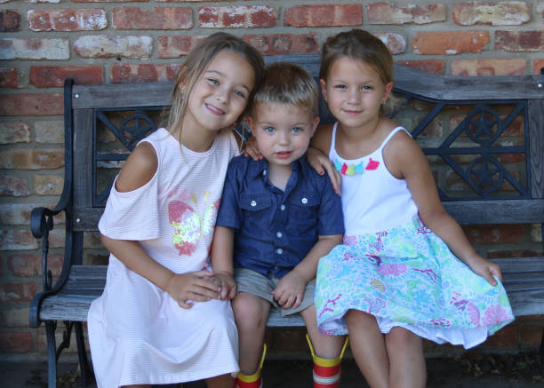 istock Young siblings bonding for picture outside on bench 1173584665