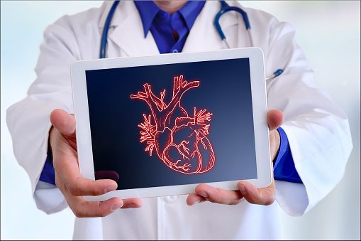 Doctor showing a picture of a heart on a tablet in a hospital