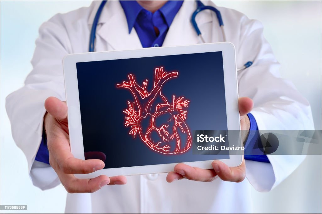 Doctor showing a heart on a tablet in front closeup Doctor showing a picture of a heart on a tablet in a hospital Heart - Internal Organ Stock Photo