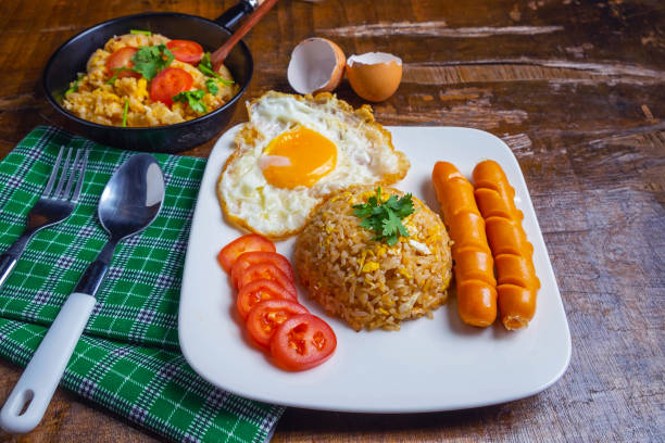 istock American fried rice served with fried eggs and sausages on the table 1173588882