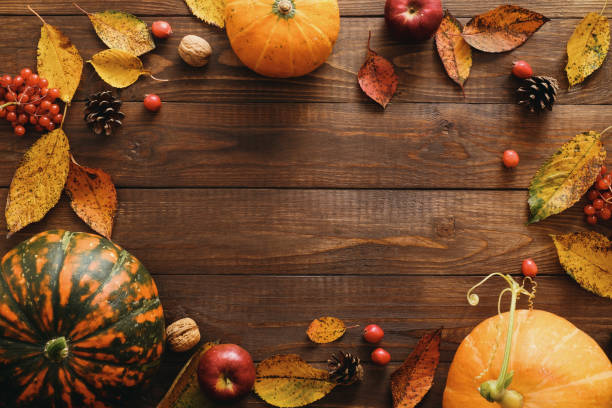 istock Autumn frame made of pumpkins, dried fall leaves, apples, red berries, walnuts, pine cones on wooden table. Thanksgiving, Halloween, Autumn Harvest concept. Flat lay composition, top view, copy space 1173589366