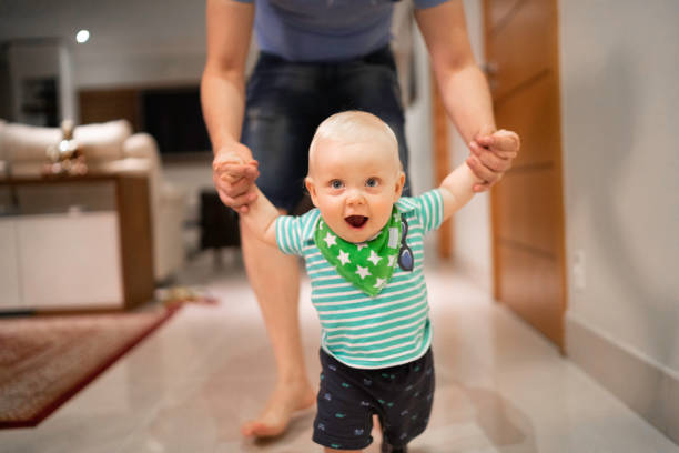 istock Father helping son learn to walk at home 1173589729