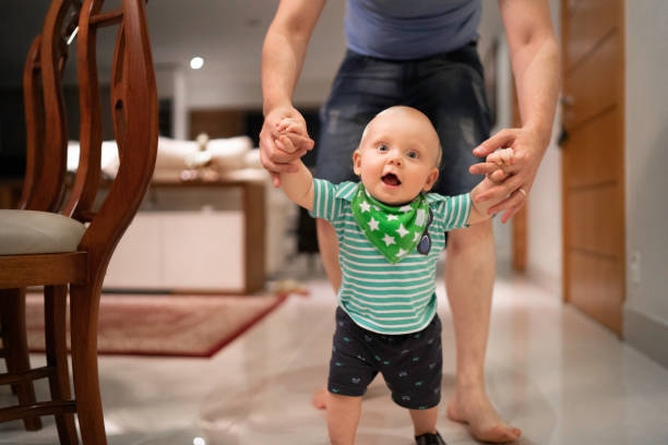 istock Father helping son learn to walk at home 1173589763