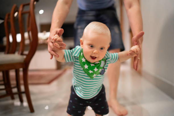 istock Father helping son learn to walk at home 1173589853