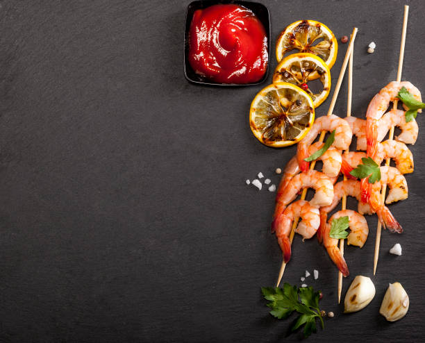 istock Prawns Shrimps with lemon, garlic and herbs on black background. Top view with copy space. 1173593479
