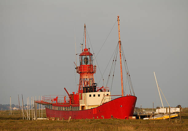 A view of the bow wave of a red ship taken from above in the prow.