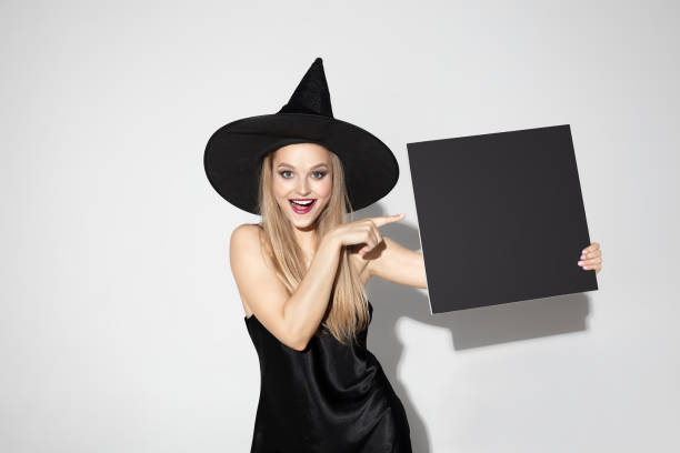 istock Young woman in hat as a witch on white background 1173597779