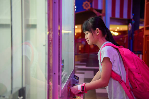 młoda azjatycka dziewczyna gra w automat do gier zręcznościowych - amusement arcade machine toy leisure games zdjęcia i obrazy z banku zdjęć